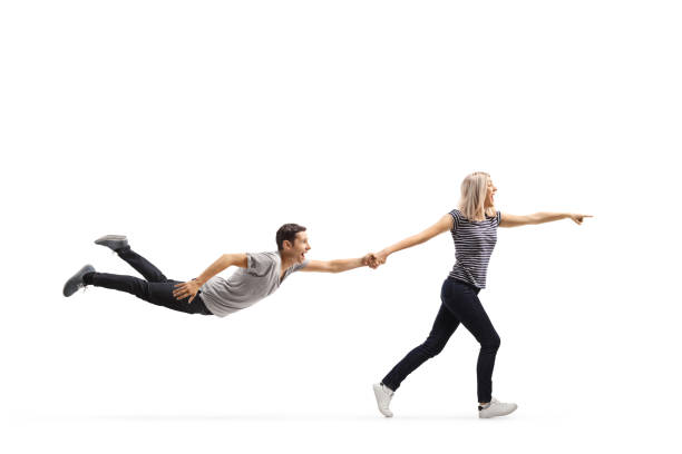 Young woman running and pointing while pulling a man by the hand isolated on white background