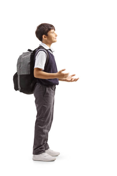 istock Schoolboy in a uniform standing and gesturing with hands 1264720380