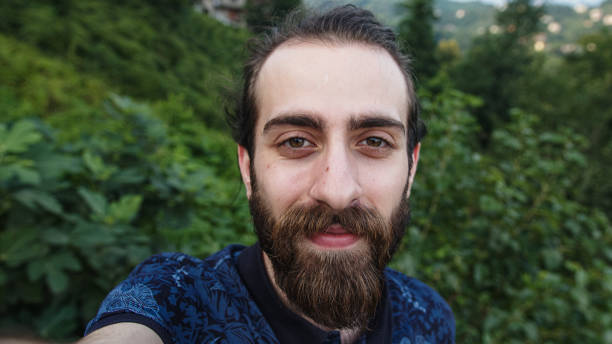 istock Hipster man with making video call with camera in hands POV close-up 1264722654