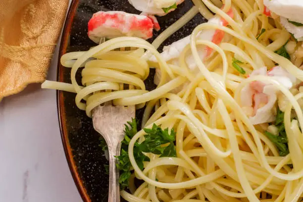 Italian crab scampi over linguine pasta with parsley garnish