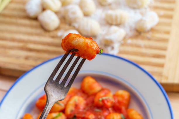 Italian gnocchi in red marinara tomato sauce with basil on wooden kitchen table