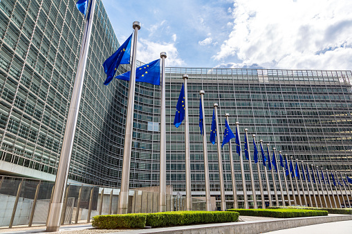 European flags in front of  headquarters of European commission in Brussels in summer day