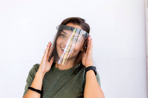 istock A woman with a protective helmet against KOVID19 poses on a white background, isolated 1264736856