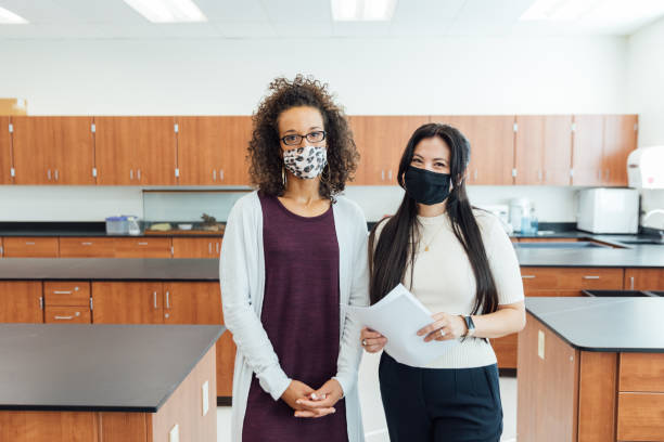 High School Teachers at School during COVID-19 High school students and teenagers go back to school in the classroom at their high school. They are required to wear face masks and practice social distancing during the COVID-19 pandemic. They value their education and are excited to be in school. high school high school student science multi ethnic group stock pictures, royalty-free photos & images