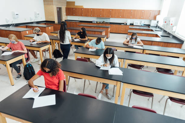 High School Students at School during COVID-19 High school students and teenagers go back to school in the classroom at their high school. They are required to wear face masks and practice social distancing during the COVID-19 pandemic. They value their education and are excited to be in school. Image taken in Utah, USA. high school high school student science multi ethnic group stock pictures, royalty-free photos & images