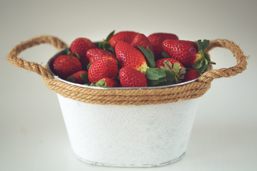 Bucket of strawberries on the white background