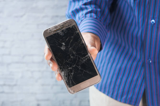 istock Close up of man hand holding broken smart phone. 1264763145