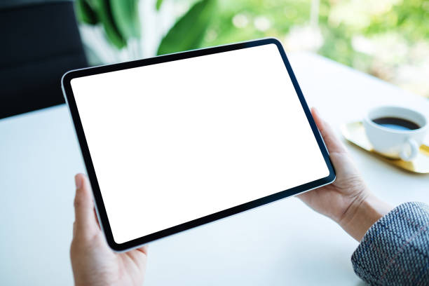 istock a woman holding digital tablet with blank white desktop screen in the office 1264769567