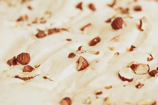 Abstract background from meringue sprinkled with crushed almonds