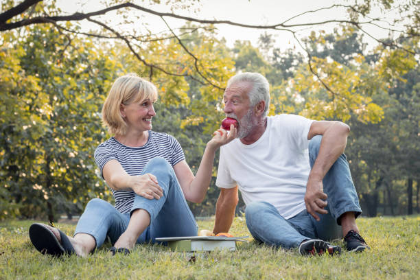 istock Couples senior give apples to each other together happily. 1264779666