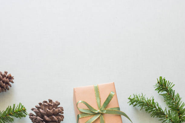 istock Christmas background with gift boxes, pine cone and decorations on light blue background. Preparation for holidays. Top view with copy space. 1264779670