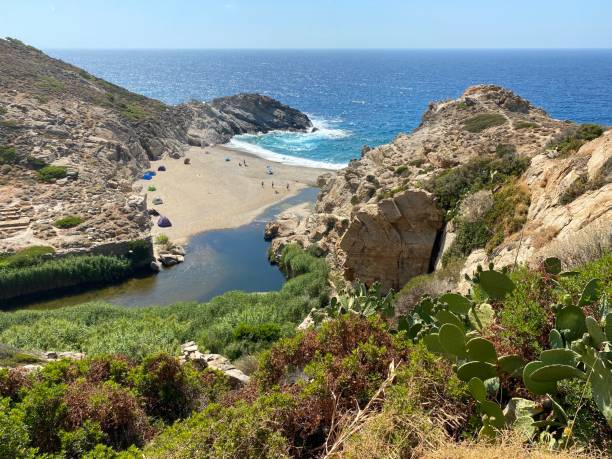 Secret Beach Sport in Ikaria, Greece Tiny sandy bay with tents in Ikaria, Greece ikaria island stock pictures, royalty-free photos & images