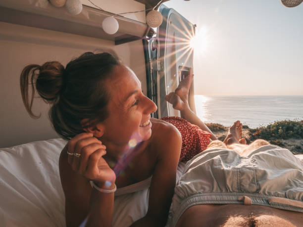 istock Couple lying at the back of a van looking at ocean 1264785467