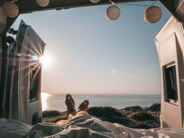 istock man lying at the back of a van looking at ocean, personal perspective 1264785508
