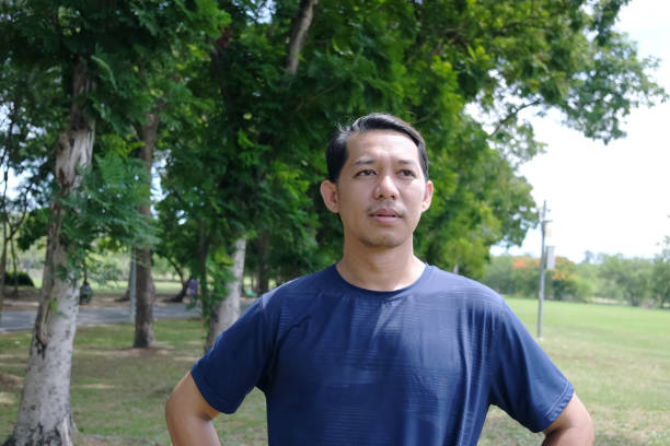 istock Smiling Asian man relaxing and refreshing after excercise and running in the park 1264786154