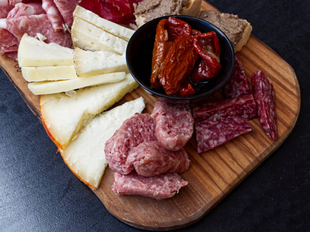 istock Rustic Tuscan tray with typical products: prosciutto (ham), brawn, finocchiona, crostini, salami, tuscan chilli and sliced pecorino ​​cheese. San Gimignano, Siena, Italy 1264790979