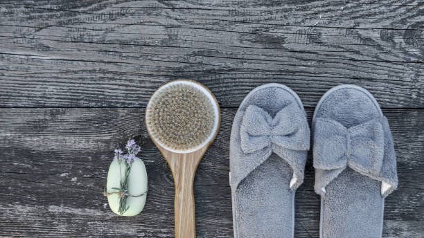 Spa and wellness setting with bathrobe, brush, soap with lavender scent, slippers