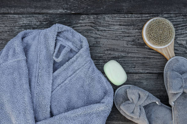 istock Spa and wellness setting with bathrobe, brush, soap with lavender scent, slippers 1264795145