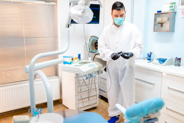 istock Dental assistant preparing dental drill while montaging diamond carbide dental bur so dentist can have everything prepared for appointment 1264797557