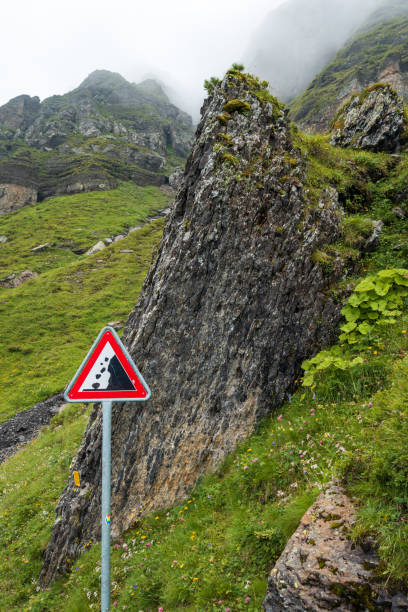 znak ostrzegawczy wskazuje na niebezpieczeństwo upadku skały na szlaku turystycznym panoramy w alpach szwajcarskich - wengen mountain peak eiger field zdjęcia i obrazy z banku zdjęć