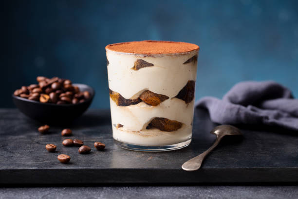 大理石のボード上のガラスのティラミスデザート。青の背景。クローズアップ。 - tiramisu dessert italian culture mascarpone cheese ストックフォトと画像