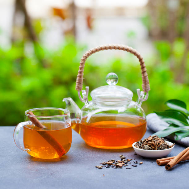 istock Tea in glass cup and teapot on summer outdoor background. Copy space. 1264802086