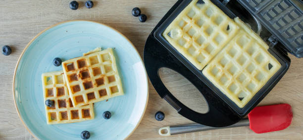 istock Waffles Being Baked in the Waffle Maker. Savory waffles. Breakfast concept 1264802354