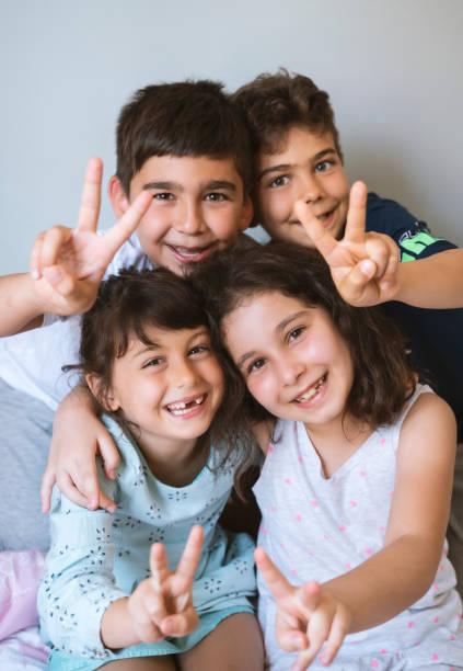 hermanos y primos animando en casa - cousin fotografías e imágenes de stock