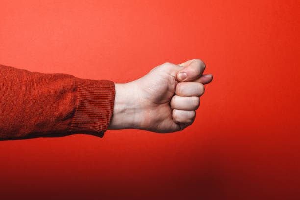 istock Man hand shows fig sign on red background 1264812132