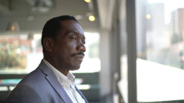 istock Businessman looking through window contemplating and thinking on the office 1264813545