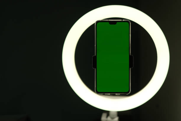 istock close up one green screen phone in front of circular LED light. live commerce concept 1264815419