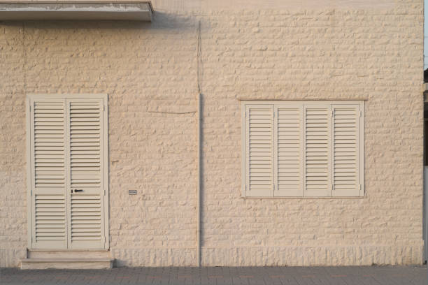 minimalist window and front door on cream-coloured brickwall