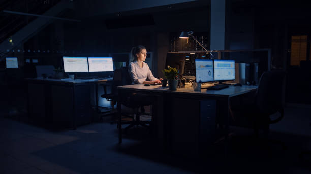 istock Working Late at Night in the Office: Businesswoman Uses Desktop Computer, Analyzing, Using Documents, Solving Problems, Finishing Important Project. Diligent Ambitious Young Worker 1264819623