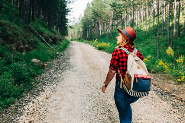 istock Young female nature explorer walking on mountain dirt road 1264819919