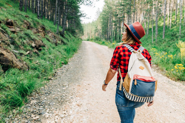 istock Young female nature explorer walking on mountain dirt road 1264819922