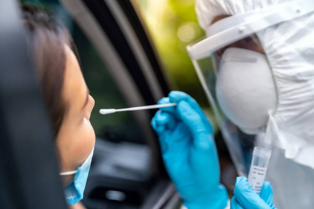 азиатская женщина drive thru covid-19 тестирования с медицинским персоналом сиз - specimen holder фотографии стоковые фото и изображения