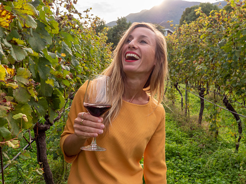 Woman with glass of wine in vineyard