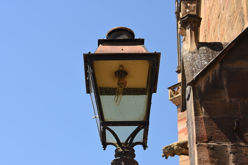 Old street lamp with new bulb in the vicinity of the St. Martin's Church in French town Colmar.