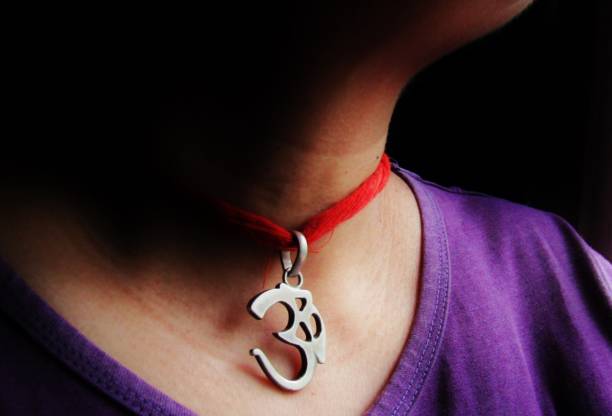 A pendant representing the OM symbol worn around the neck with a sacred thread.