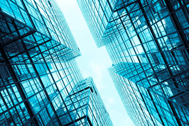 Low wide-angle view looking up to modern skyscrapers in business district on a beautiful sunny day with blue sky