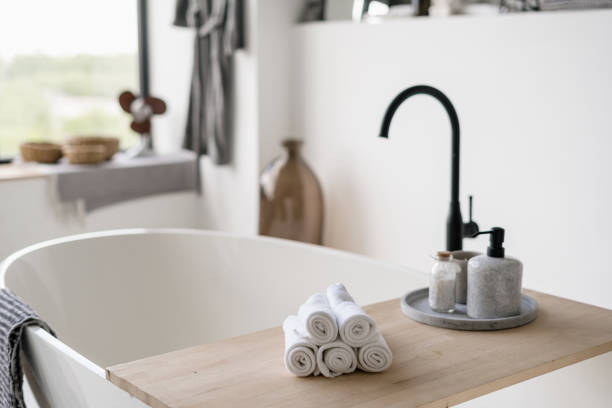 istock Towels on tub with modern black water tap at blurred background 1264831187