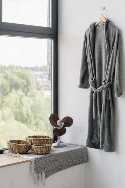istock Bathrobe hanging at wall near window with house decor 1264831251