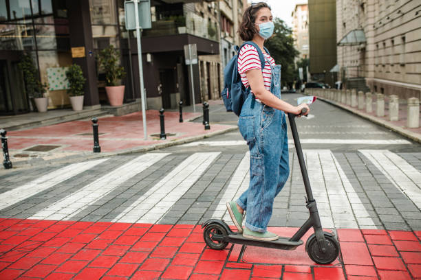 istock Young woman with a protective mask on electric scooter 1264834972