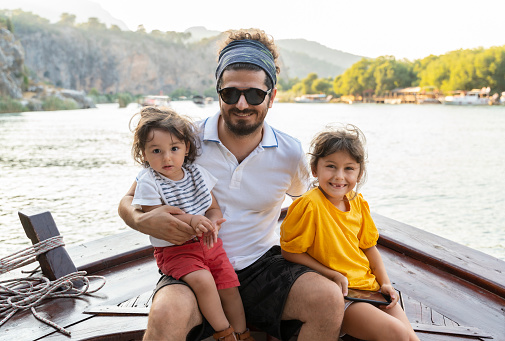 Father with his son and daughter sailing a rowboat in Dalyan, Mugla, Turkey