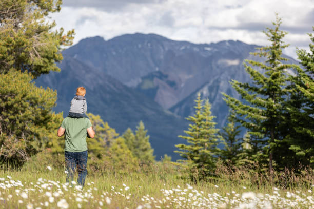 istock Father carrying his Son on Shoulders in Mountains 1264836704
