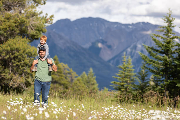 istock Father carrying his Son on Shoulders in Mountains 1264837916