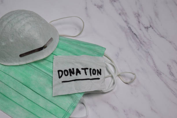 istock Donation write on sticky notes with health mask isolated on office desk 1264840637