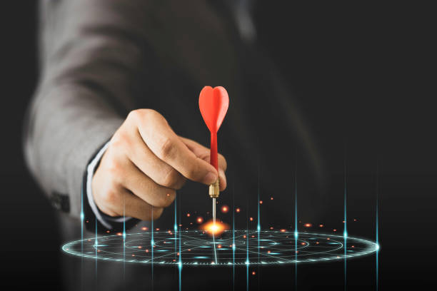 istock Businessman holding and throwing red arrow dart to virtual target dart board. Setup objectives and target for business investment concept. 1264841081