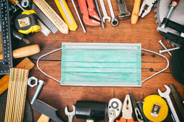 Worker hand tools and protective mask on wooden background