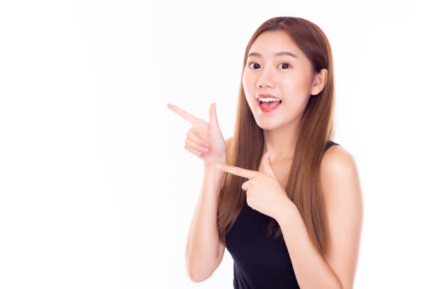 Beautiful young asian woman pointing finger to copy space with happiness and smiley face. Attractive beautiful girl act like a introduce or present product, use for advertising isolated on white Beautiful young asian woman pointing finger to copy space with happiness and smiley face. Attractive beautiful girl act like a introduce or present product, use for advertising isolated on white beautiful women giving head stock pictures, royalty-free photos & images
